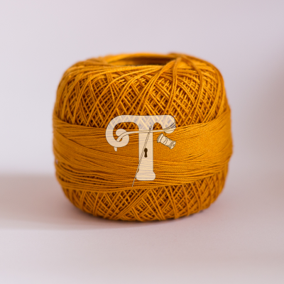 Rolo de linha amarelo-mostarda sobre superfície branca