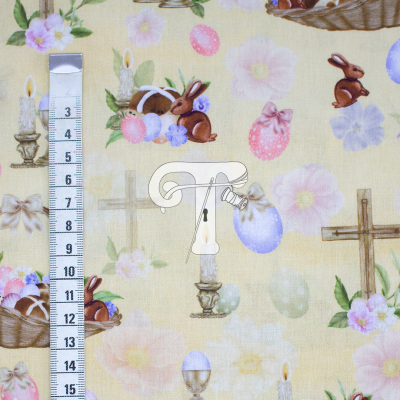 Tecido estampado de Páscoa com coelhos, ovos, flores, velas, pão e cruzes sobre fundo amarelo