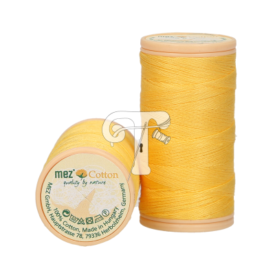 Dois carretéis de linha de algodão amarelo, um em pé e outro deitado com rótulo visível