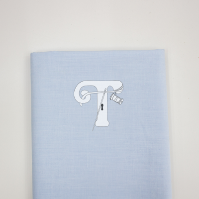 tecido azul com ilustração de letra T e carretel de linha