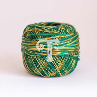 Novelo de linha verde e amarelo em fundo branco