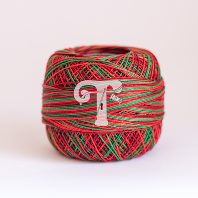 Novelo de fio colorido vermelho, verde e preto sobre fundo claro