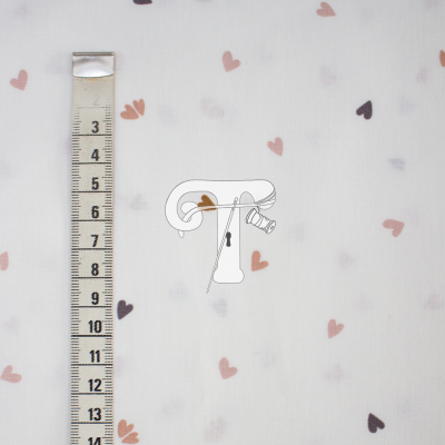 Tecido branco com corações coloridos em tons pastel e fita métrica ao lado.