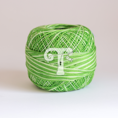 Rolo de linha verde e branco listrado com textura fina sobre fundo cinzento claro