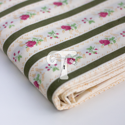 Tecido dobrado com padrão flores cor-de-rosa e listas verdes sobre fundo bege