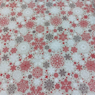 Tecido bege com flocos de neve vermelhos, brancos e castanhos em padrão repetido