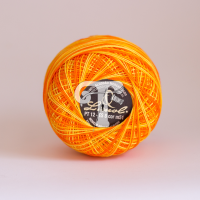 Rolo de linha de algodão amarelo e laranja com etiqueta preta central