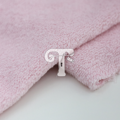 Pano felpudo cor-de-rosa claro sobre superfície branca