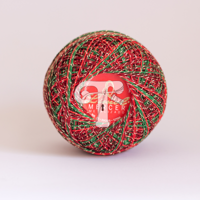 Bola de fio multicolor vermelho, verde e dourado com etiqueta central num fundo branco.