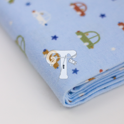 Tecido azul claro com padrão de carrinhos coloridos e pequenas estrelas