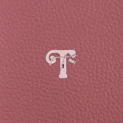 Textura de couro rosa com letra T decorada com agulha e linha