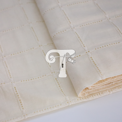 tecido creme claro dobrado com padrão quadriculado e relevo