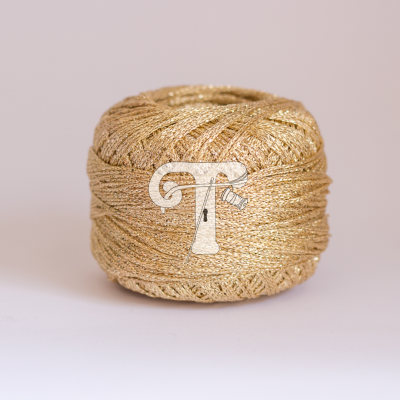 Bola de fio dourado brilhante sobre superfície branca