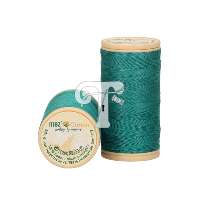 Duas bobinas de linha de algodão verde água com recipientes bege e etiqueta com texto e símbolos de cuidado