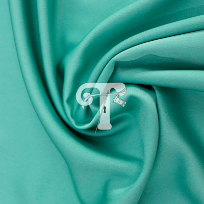 Tecido verde água com logótipo branco em forma de T