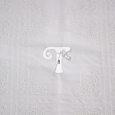 Tecido branco bordado com padrão geométrico e floral