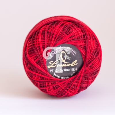 Novelo de linha de algodão mercerizado vermelho com etiqueta preta no centro