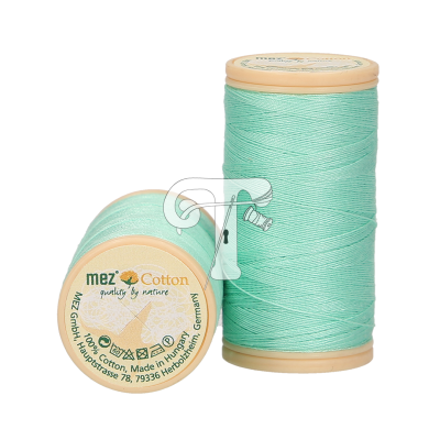 Dois carretéis de linha verde-água com tampa bege, um de pé e outro deitado com texto na tampa.