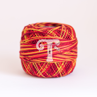 Rolo de linha vermelha e amarela sobre superfície branca