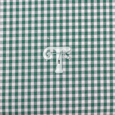 Tecido às quadrículas verde e branco com etiqueta branca no centro