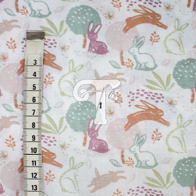 Tecido com padrão de coelhos coloridos e fita métrica ao lado.