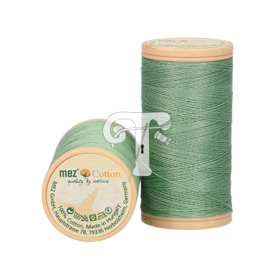 Dois carretéis de linha de algodão verde claro com tampas de madeira e texto em alemão