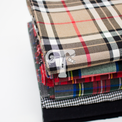 Pilha de tecidos variados com padrões xadrez e texturas diferentes