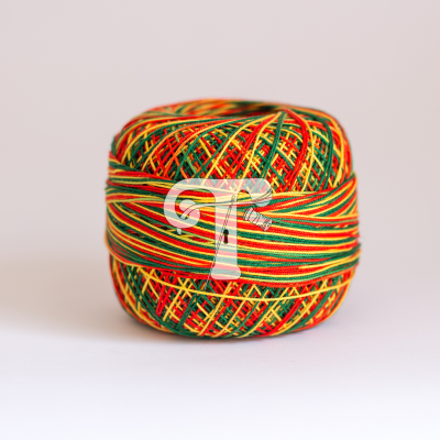 Novelo de linha multicolorido com padrões entrelaçados em tons de vermelho, amarelo e verde