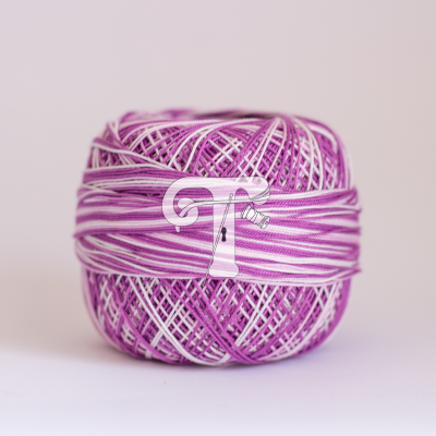Novelo de fio roxo e branco sobre fundo claro