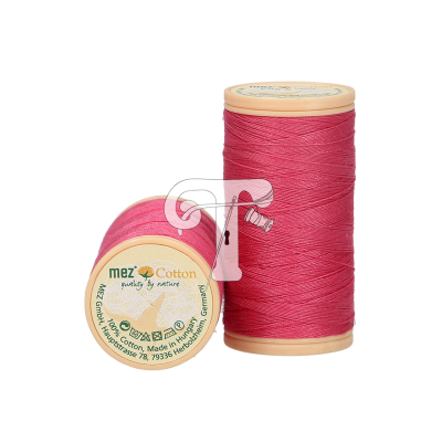 Dois carretéis de linha de cor-de-rosa em carretéis de plástico bege, um em pé e o outro deitado com rótulo visível.