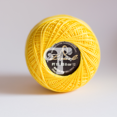 Rolo de linha de algodão amarelo com etiqueta preta central