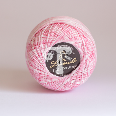 Novelo de linha rosa claro e branco com etiqueta preta da marca Lizziol