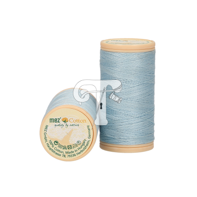 Carretéis de linha de algodão azul claro com tampas bege e etiqueta com texto visível