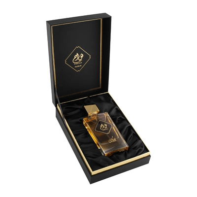 Frasco de perfume âmbar em caixa preta com detalhes dourados