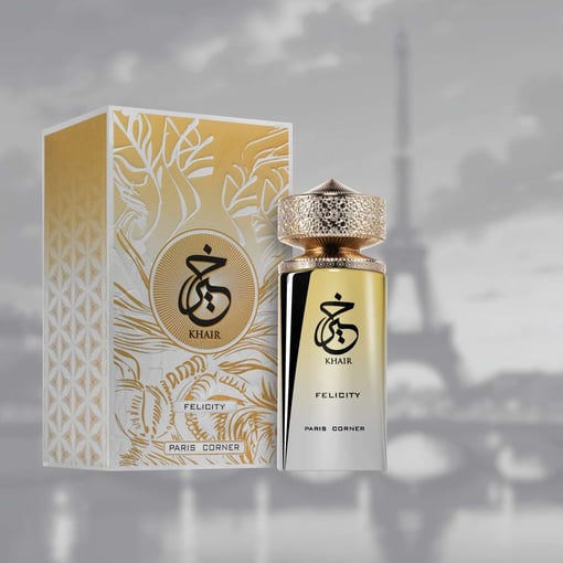 Frasco de perfume dourado e branco com caixa e fundo da Torre Eiffel.