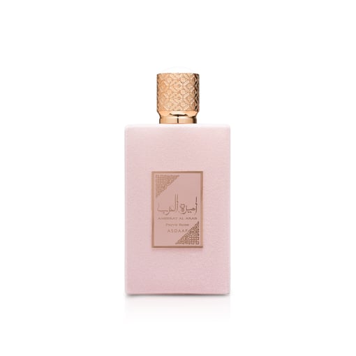 Frasco de perfume rosa claro com tampa dourada e etiqueta central