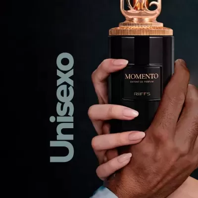 Frasco de perfume MOMENTO Extrait de Parfum RIIFFS segurado por duas mãos de cores diferentes com fundo preto e texto Unisexo