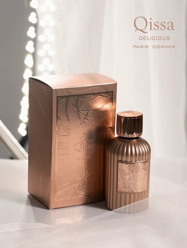 Frasco e caixa de perfume bronze com relevo de folhas e texto Qissa DELICIOUS PARIS CORNER