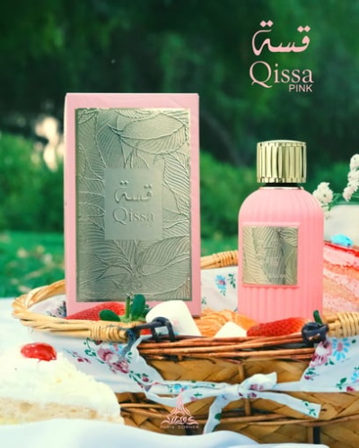 Frasco rosa de perfume e caixa decorativa sobre cesta de vime com flores