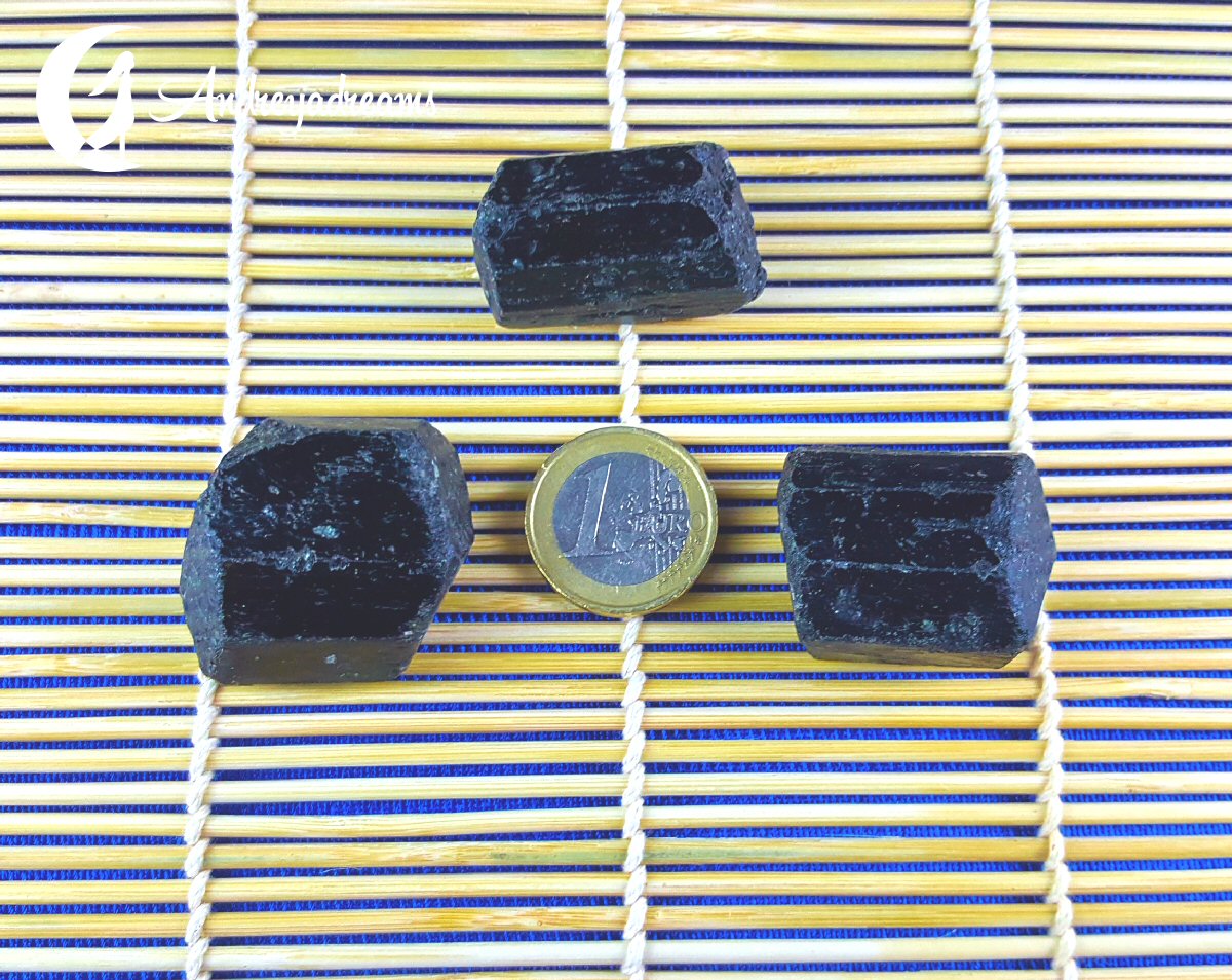 Turmalina Negra 3cm Três cristais negros hexagonais com moeda de 1 euro sobre tela de bambu