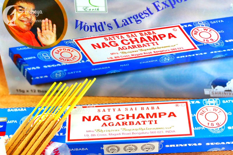 Caixas coloridas de incenso Nag Champa Agarbatti com varas de incenso e imagem de uma pessoa ao fundo