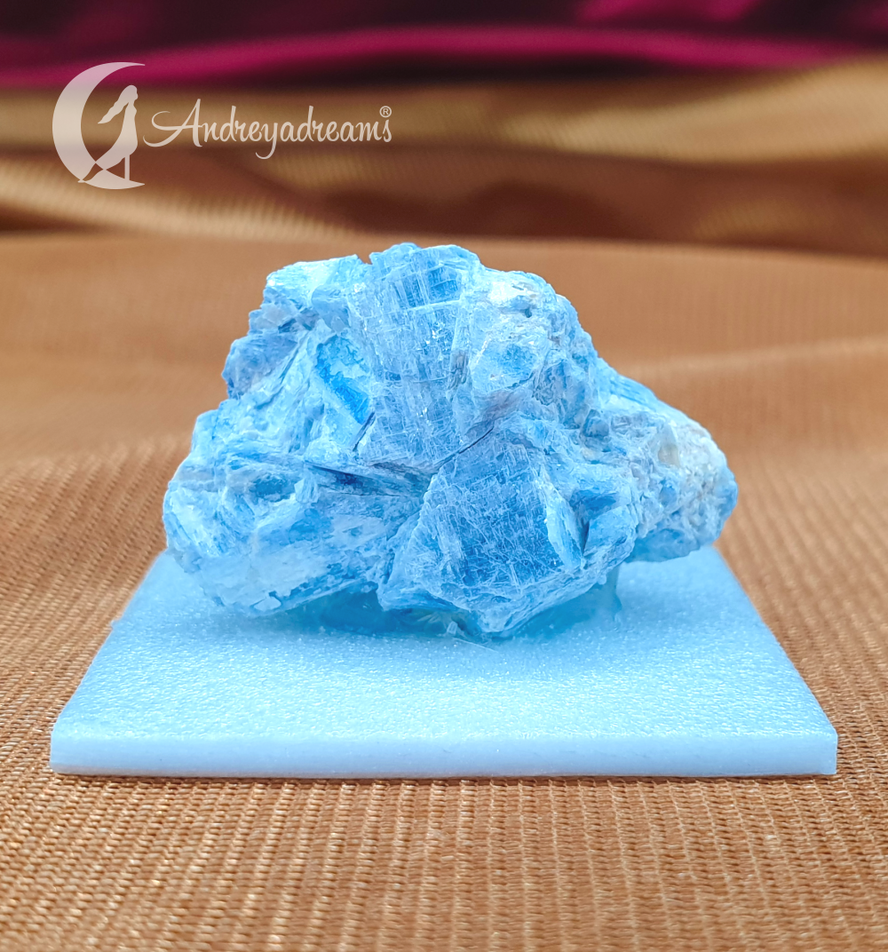 Cianite Azul Mineral azul irregular sobre base azul clara em fundo castanho