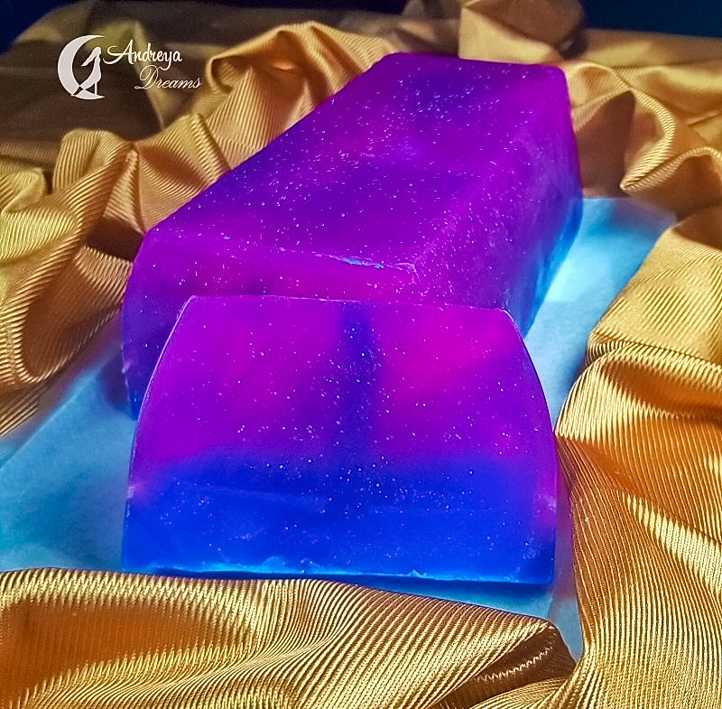 Limpeza Energética Pessoal Sabonete translúcido roxo e azul sobre tecido dourado