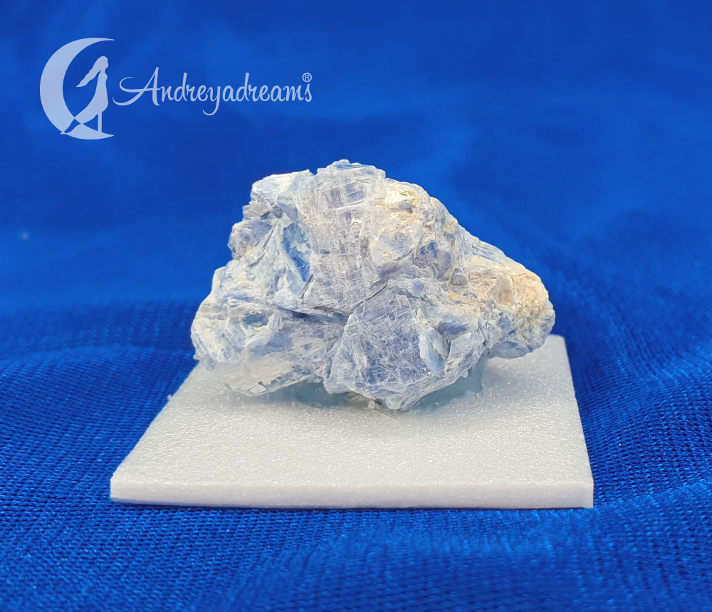 Cianite Azul Cristal mineral azul claro sobre base branca em fundo azul