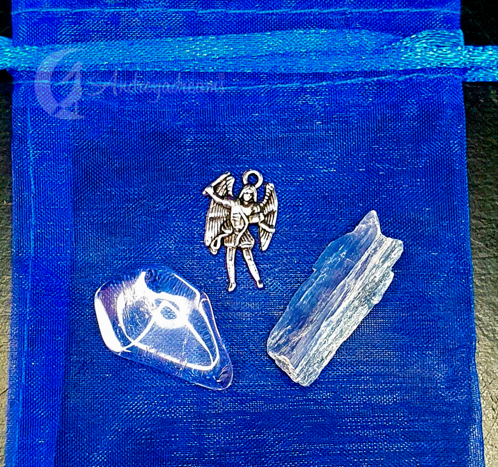 Kit Arcanjo Miguel saquinho azul com duas pedras brancas e um pingente de anjo prateado