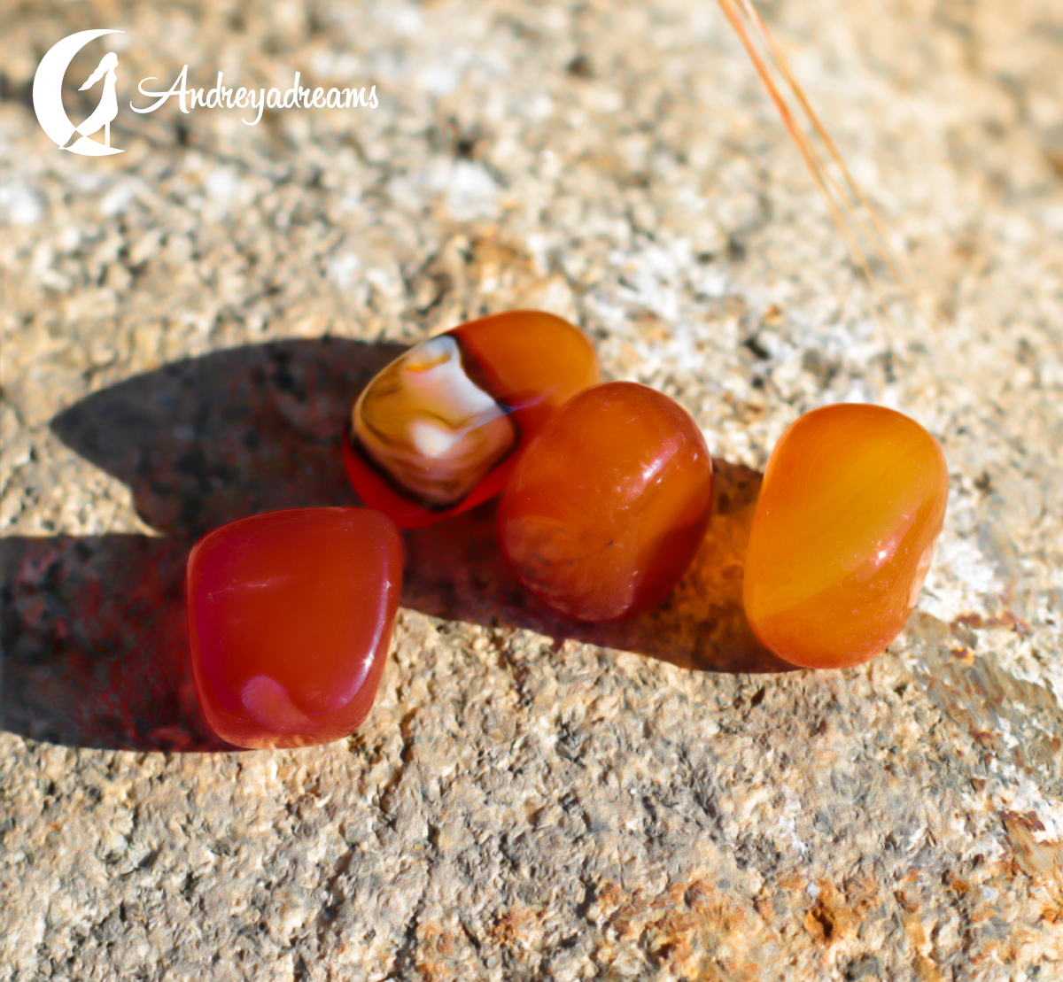 Cornalina Pedras polidas vermelhas e laranja sobre superfície de pedra cinzenta com texto Andreyadreams