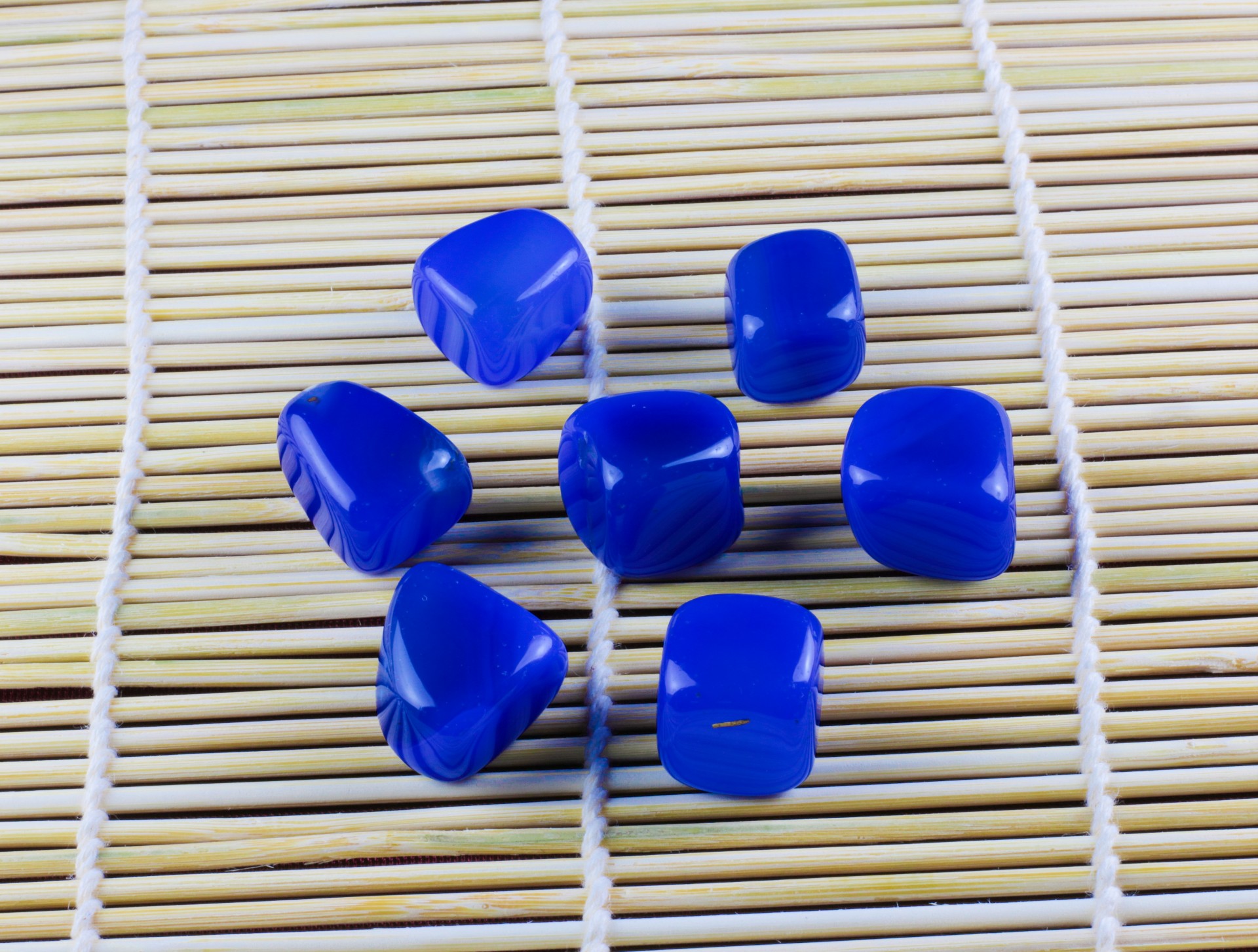 Ágata Azul Seis pedras azuis com padrões brancos sobre tapete de bambu