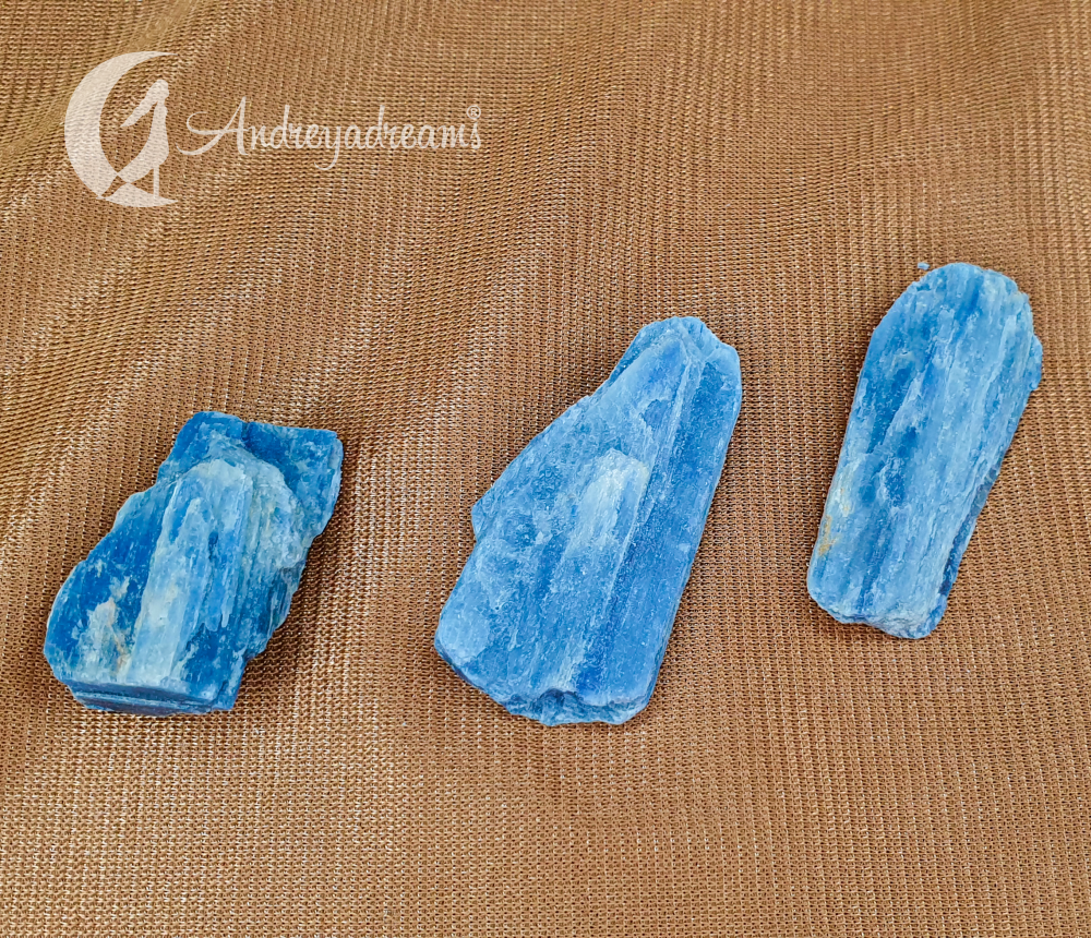 Cianite Azul Três pedras azuis em fundo castanho com logo Andrayadreams