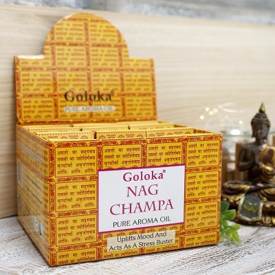 Caixa amarela de óleos aromáticos Goloka Nag Champa com estátua de Buda ao fundo