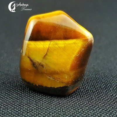 pedra polida amarela e castanha sobre fundo tecido negro